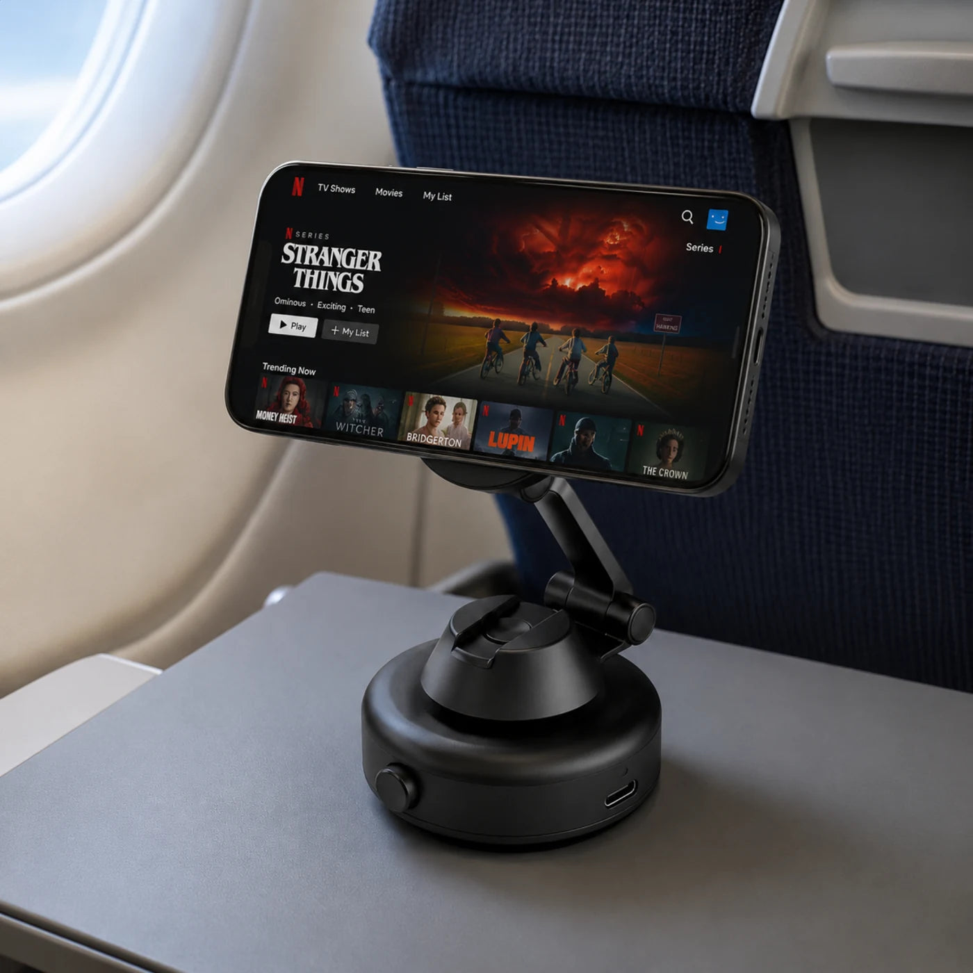 Autogrip Pro telefoonhouder met telefoon, opgesteld op een reistafeltje